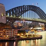 Sydney Harbour Bridge illuminated at dusk.