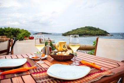Seaside dining setup with wine overlooking the Ionian sea in Ksamil.