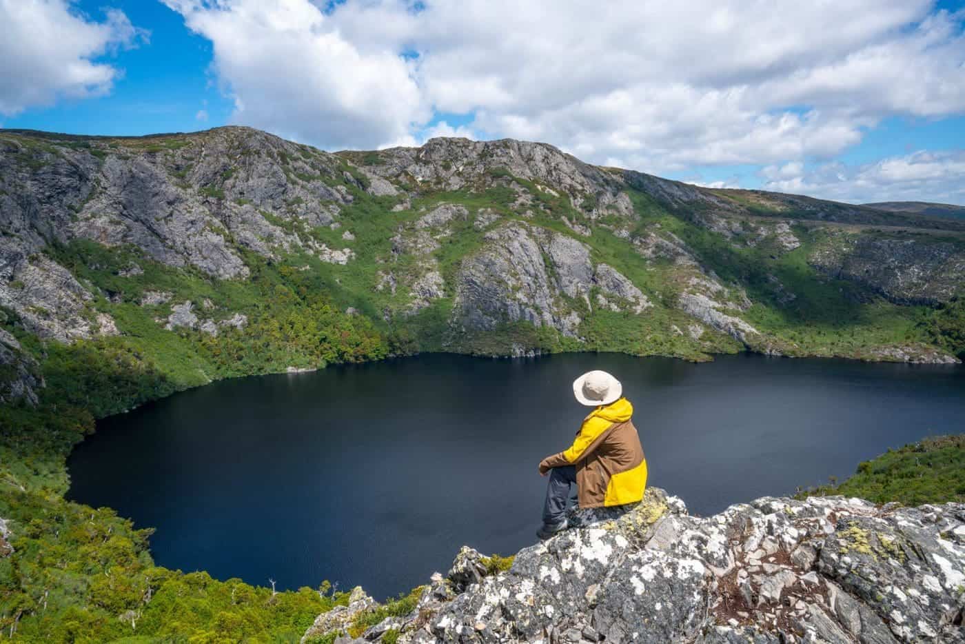 Hiker overlooking mountain lake in Cradle Mountain, Tasmania.