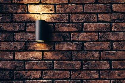 Brick accent wall with modern sconce lighting.
