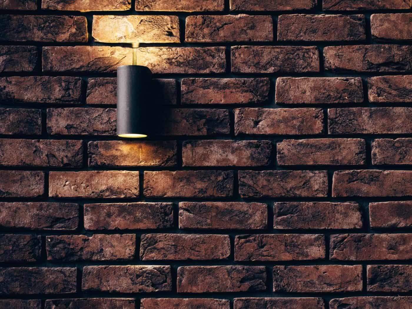 Brick accent wall with modern sconce lighting.