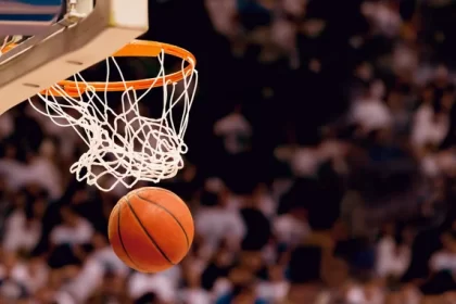 Basketball approaching net in mid-game action shot.