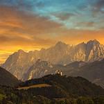 Alpine mountain range at sunset with colorful sky.