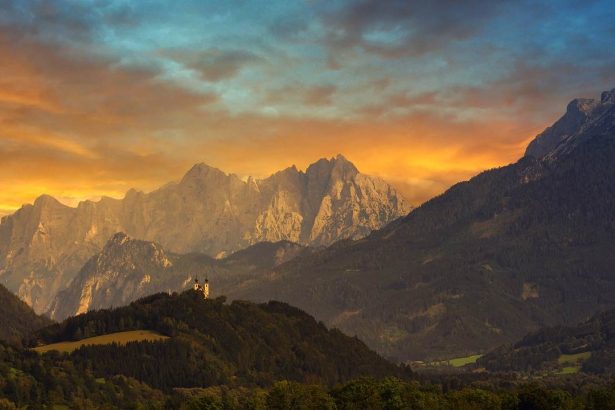 Alpine mountain range at sunset with colorful sky.