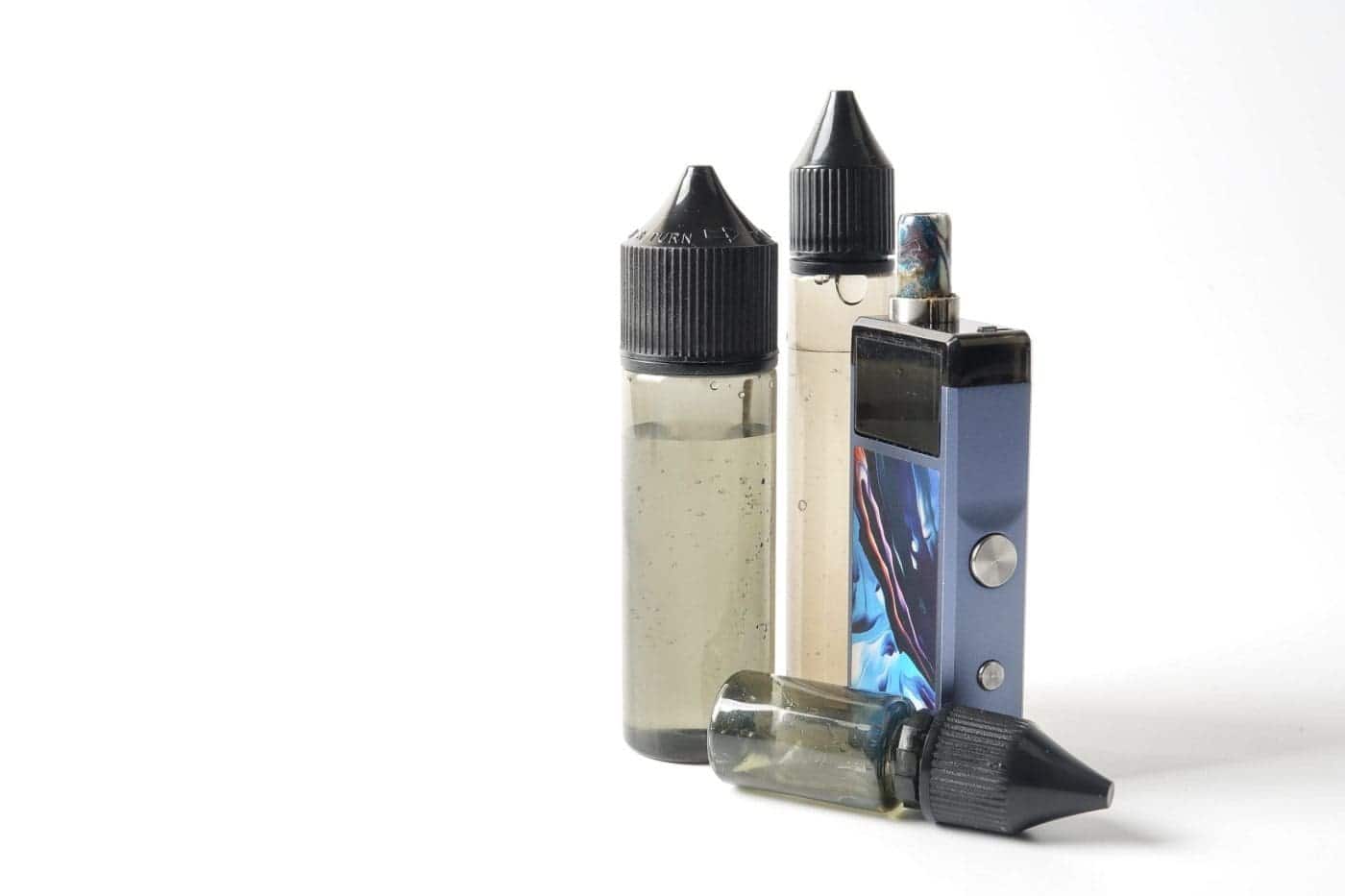 E-cigarette with refill bottles on white background.
