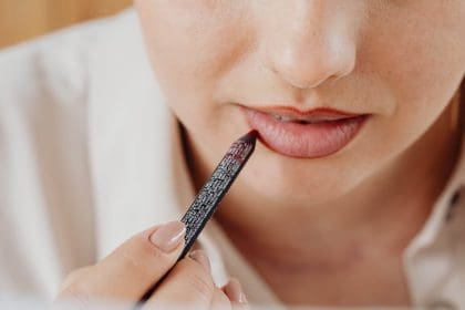 Close-up of person applying lip liner for makeup enhancement