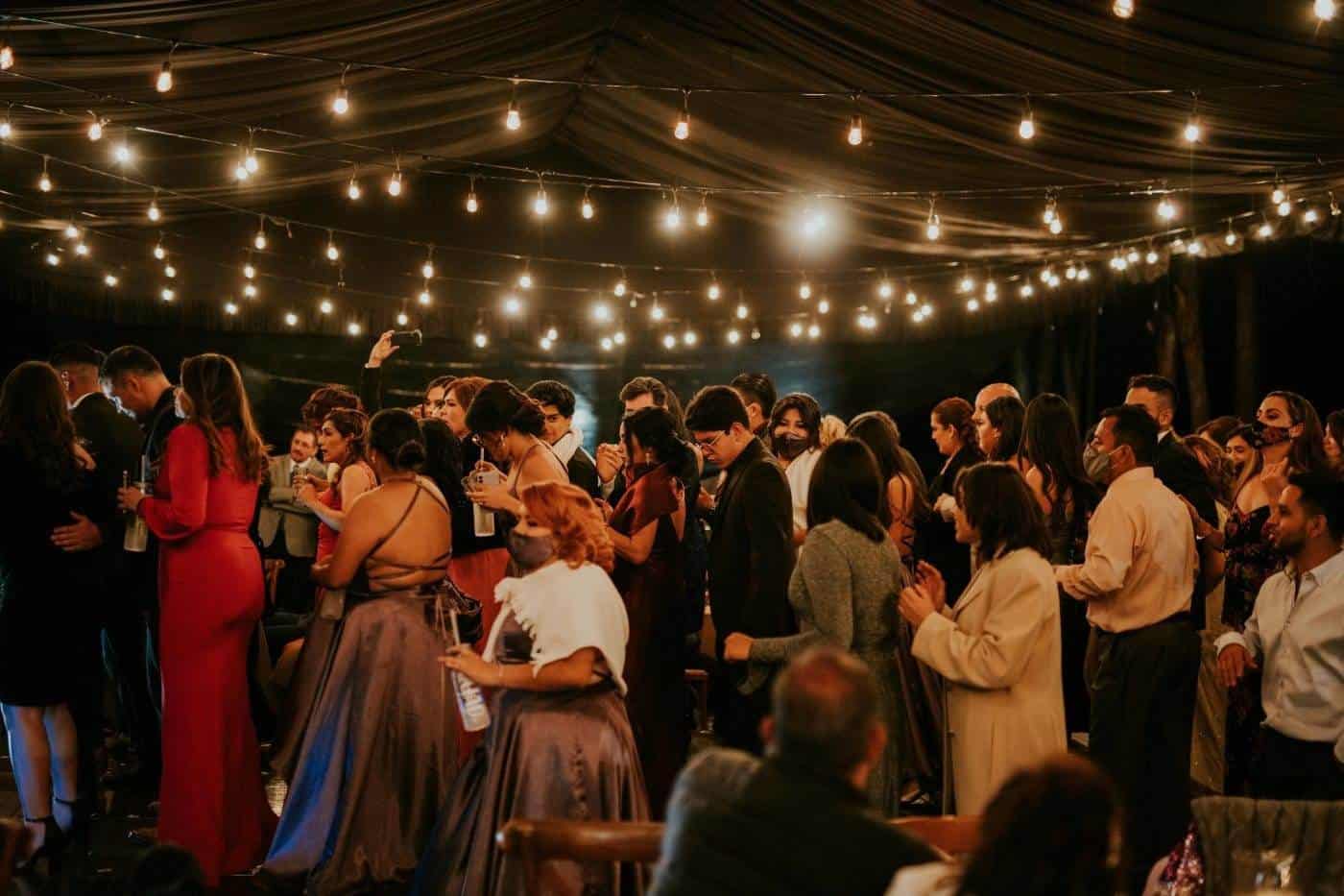 Evening wedding reception with guests under string lights.