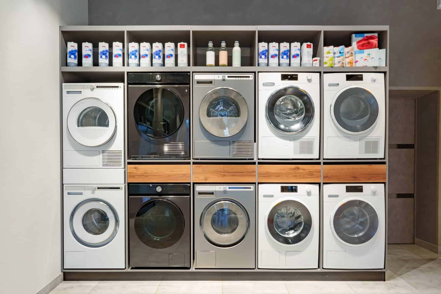Row of washing machines at a modern laundromat with prices.
