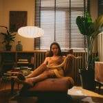 Cozy home interior with woman relaxing on armchair.