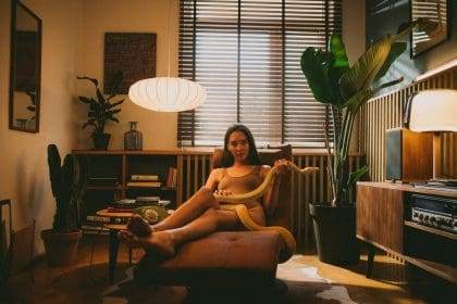 Cozy home interior with woman relaxing on armchair.