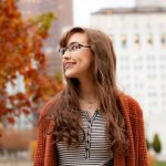 Woman smiling with braces in autumn setting
