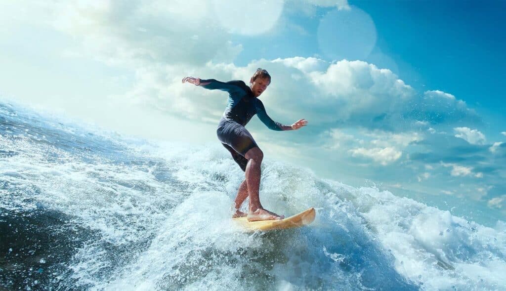 Surfer riding a wave at Bondi Beach under a bright blue sky